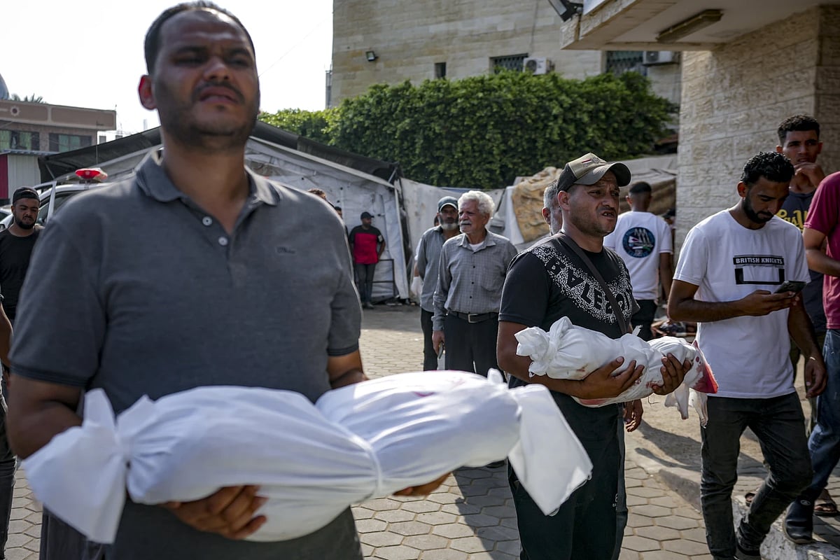 AP : Palestinians hold bodies of their relatives killed in Israeli bombardments |